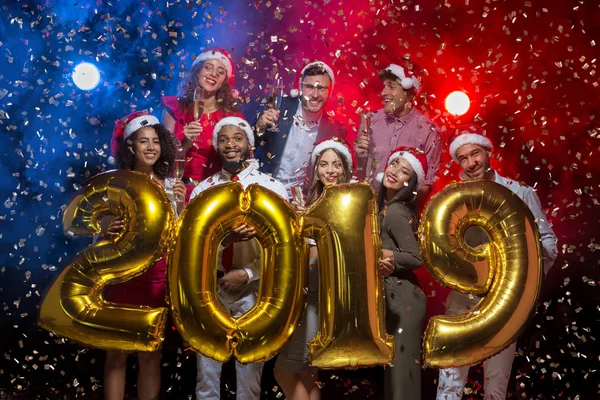 Vänner håller 2019 gyllene ballonger vid nyår party — Stockfoto