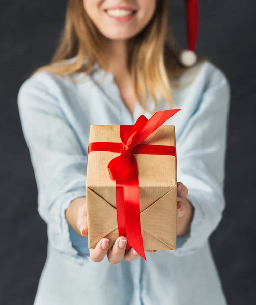 Young opgewonden vrouw in kerstmuts met cadeau — Stockfoto