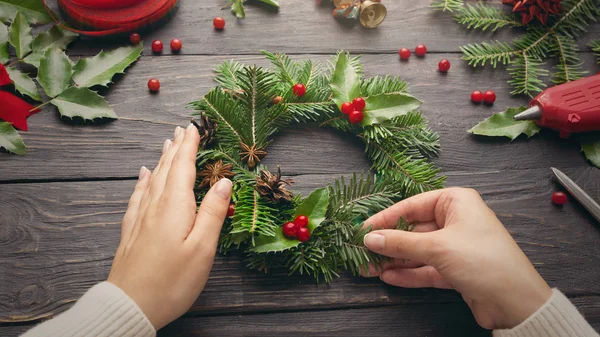 Női kéz, hogy a Karácsonyi koszorú — Stock Fotó