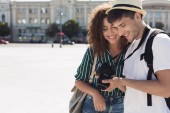 Turistické pár na kameru při pohledu na fotografie