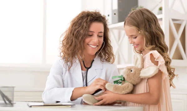 Pédiatre jouer avec fille jouet dans clinique — Photo