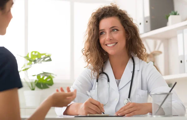 Médecin travaillant au bureau et écoutant le patient — Photo