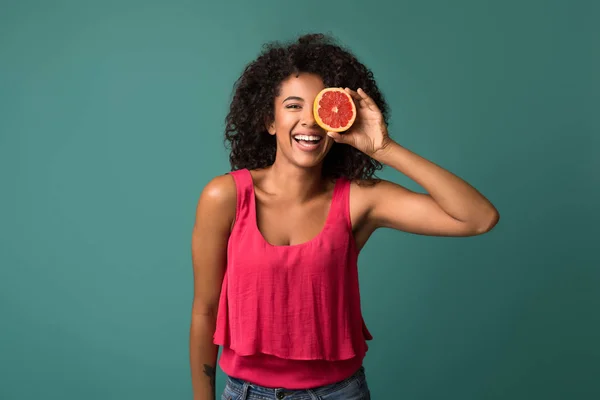 グレープ フルーツの半分を保持している幸せのアフリカ系アメリカ人の女性 — ストック写真