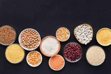 Siyah arka plan üzerine çeşitli kase tahıl ve baklagiller