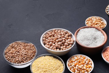 Koyu arka plan üzerinde kase tahıl çeşitler