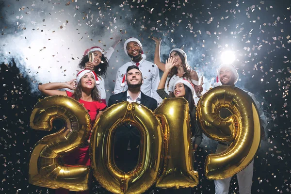 Des amis multiethniques tenant des ballons 2019 à la fête du Nouvel An — Photo