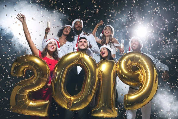 Mnohonárodnostní přátel drží 2019 balónky na novoroční párty — Stock fotografie