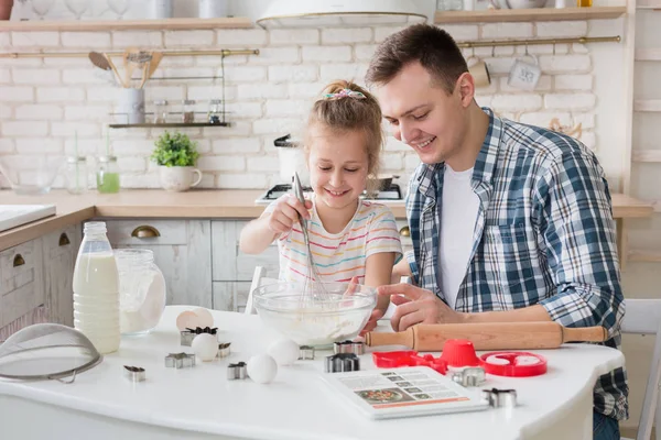 Dad and daughter mixing dough in bowl, preparing cake