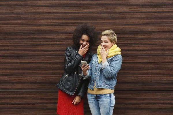 Surpreendido amigos do sexo feminino com smartphone ao ar livre — Fotografia de Stock