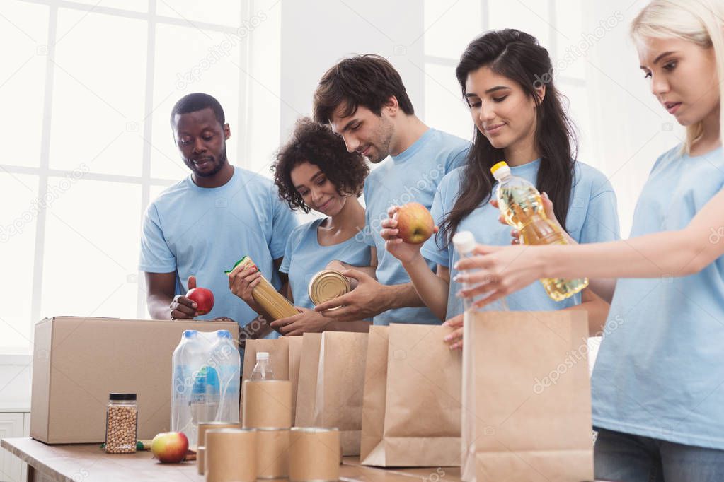 Volunteers packing food and drinks into paper bags