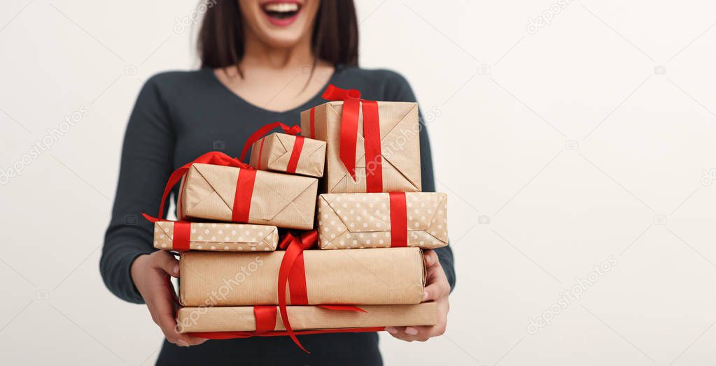 Picture of young excited woman with heap of gifts