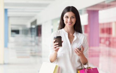 Çarşıda alışveriş yaparken Smartphone kullanan mutlu kadın