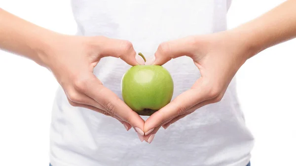 Жінка робить руки в формі серця і тримає яблуко — стокове фото