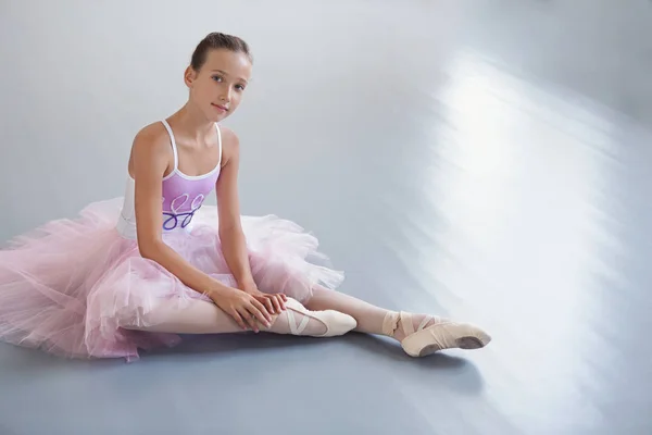 Jeune ballerine assise sur le sol dans un studio de danse — Photo