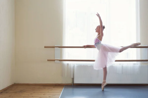 Giovane ballerina che si allunga alla sbarra del balletto in studio — Foto Stock