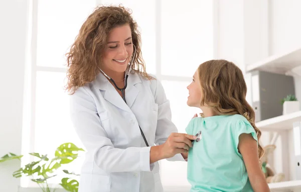 Pédiatre femme examinant fille au bureau à la clinique — Photo