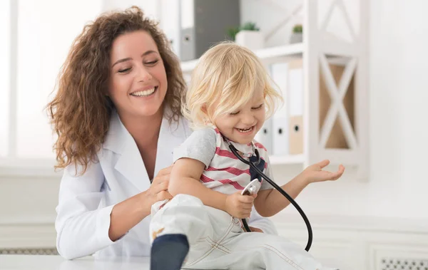 Femme médecin chatouiller petit garçon dans le bureau — Photo