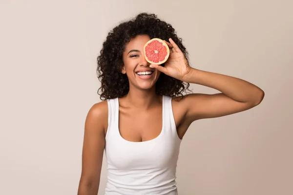 Jovem feliz segurando metade da toranja — Fotografia de Stock