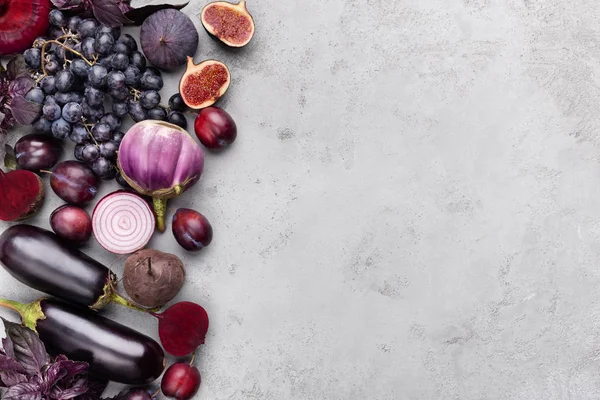 Collection of purple fruits and vegetables on gray background