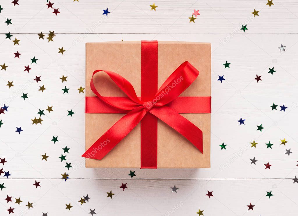 Brown gift box with red bow on white background