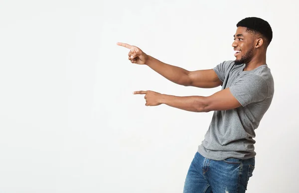 Siyah adam bir yana kopya alanı, iki parmak işaret heyecanlı — Stok fotoğraf