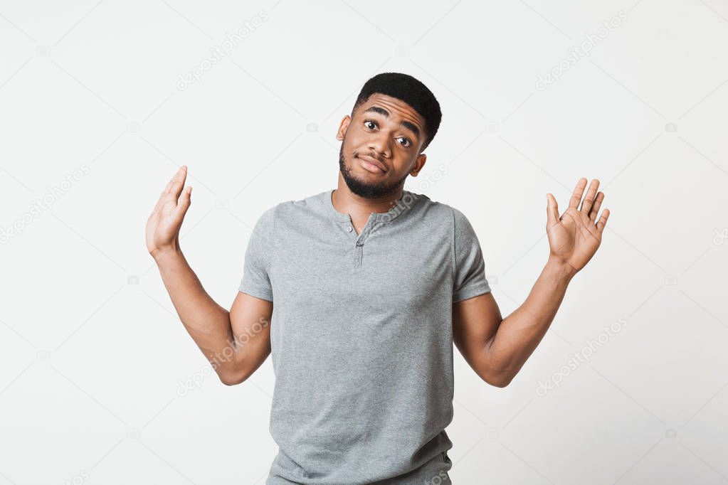 Confused black manraising his hands and looking at camera