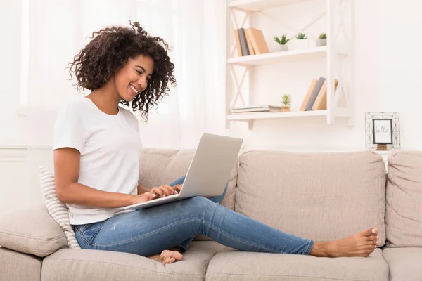 Donna afro-americana che lavora sul computer portatile a casa — Foto Stock