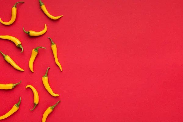 Hot yellow chilli peppers on red background — Stock Photo, Image