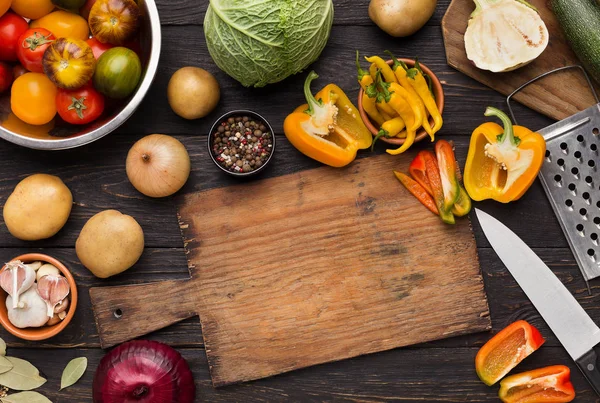 Grönsaker sortimentet på köksbordet med skärbräda — Stockfoto