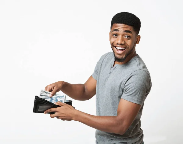 Opgewonden Afrikaans-Amerikaanse man die geld in portemonnee steekt — Stockfoto