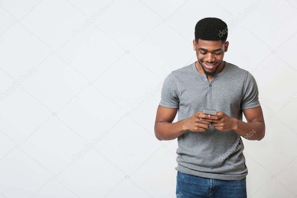 Interested african-american man using smartphone on white background