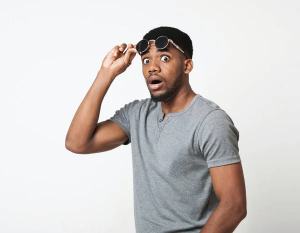 Surprised black man taking off his glasses — Stock Photo, Image