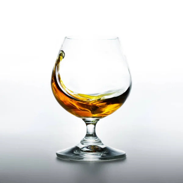 Cognac glas met spatten van brandy binnen — Stockfoto