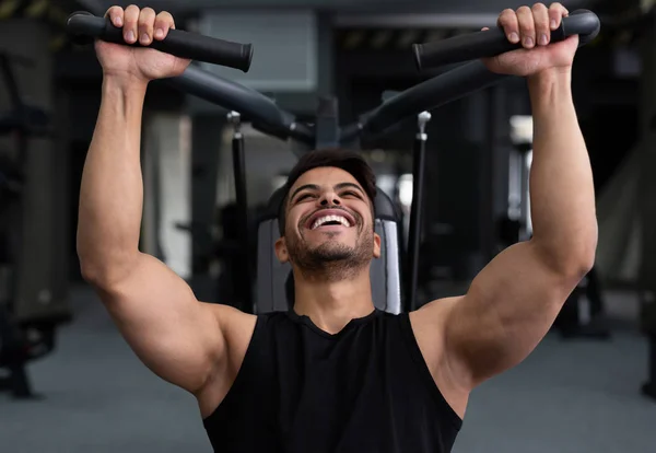 Homem treinando duro, fazendo exercício na academia de fitness — Fotografia de Stock