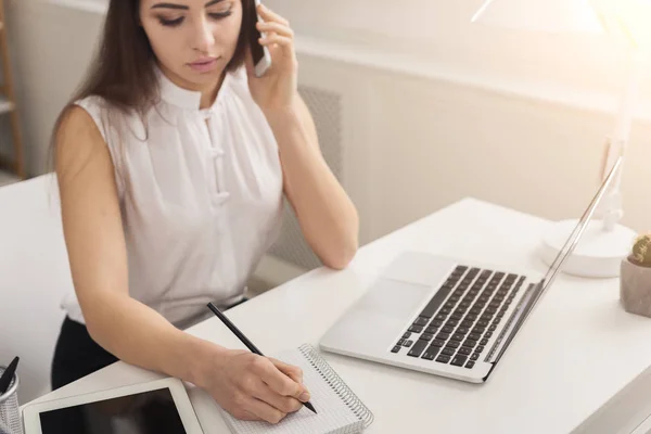 Mujer trabajando en portátil y consultoría por teléfono — Foto de Stock