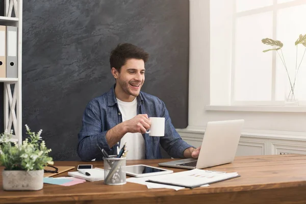 Joven empresario feliz trabajando con el ordenador portátil — Foto de Stock