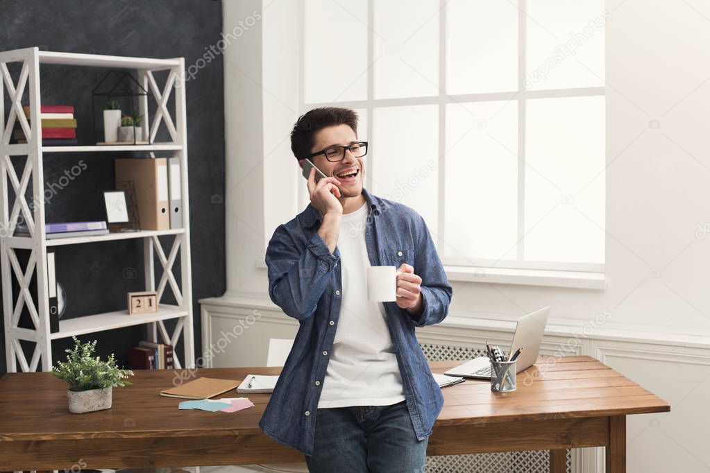Young smiling businessman has mobile talk