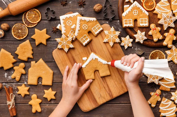 Decoratie kerst bakkerij. Vrouw beglazing zelfgemaakte koekjes — Stockfoto