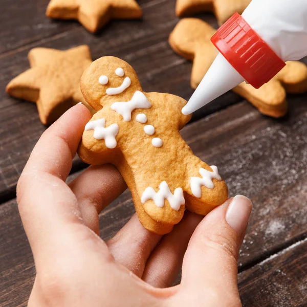 Kerst bakkerij. Vrouw handen decoreren zelfgemaakte peperkoek — Stockfoto