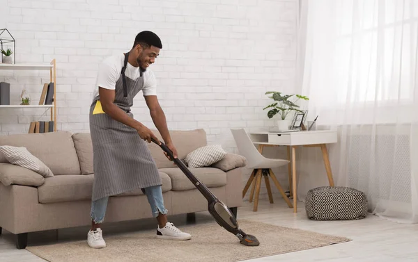 Black man cleaning house with wireless vacuum cleaner — Stock Photo, Image