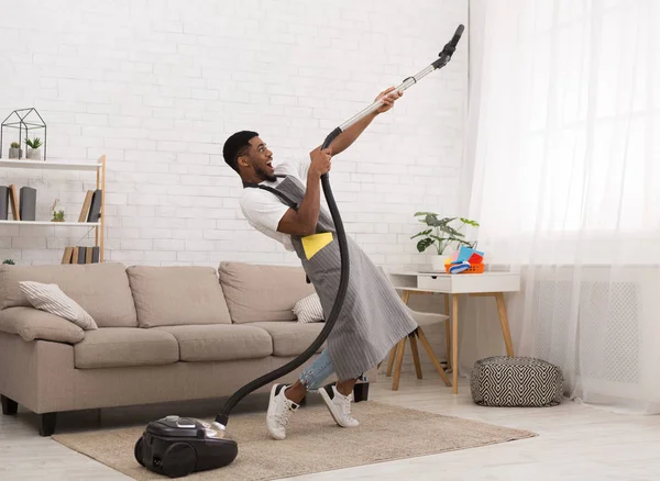 Young man cleaning house with vacuum cleaner — Stock Photo, Image