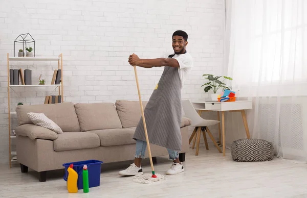 Black man with mop cleaning floor at home — Stock Photo, Image