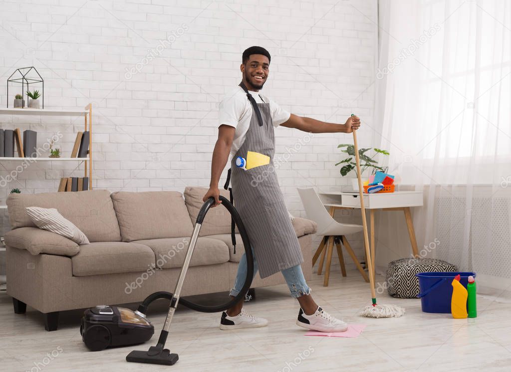 Fotos de Negro hombre piso de limpieza con aspiradora y fregona