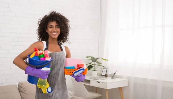 Sonriente mujer negra posando con suministros de limpieza — Foto de Stock