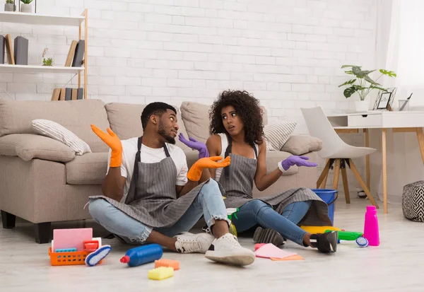 Doubtful couple cleaning house with lots of tools — Stock Photo, Image