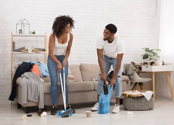Erkek ve kadın partiden sonra dağınık Oda temizliği — Stok fotoğraf