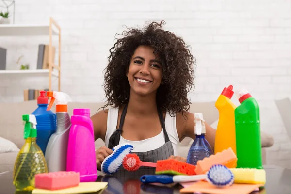 Lachende zwarte vrouw poseren met schoonmaakproducten — Stockfoto