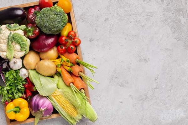 Verdure biologiche fresche in scatola di legno su grigio — Foto Stock