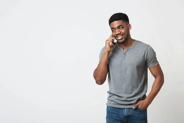 Cep telefonu üzerinde konuşurken ve gülümseyen bir Afrikalı-Amerikalı adam — Stok fotoğraf