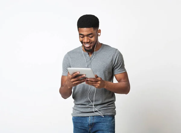 Uomo afroamericano che ascolta musica con cuffie e tablet digitale — Foto Stock